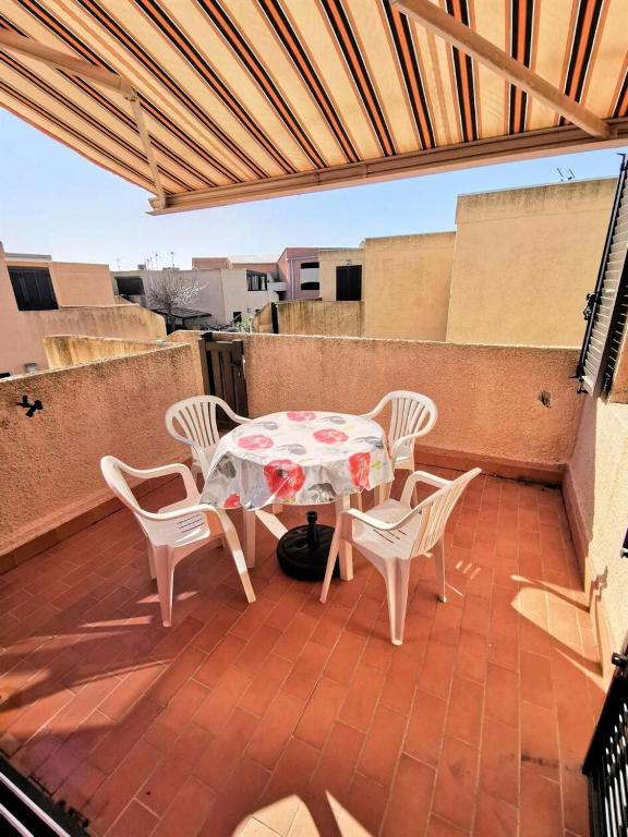un patio avec une table et des chaises sur un toit dans l'établissement Résidence Marysable - Confortable appartement deux pièces pour 4 personnes à Port Leucate. Réf: 1MAR_101 MAE-6574, à Port-Leucate