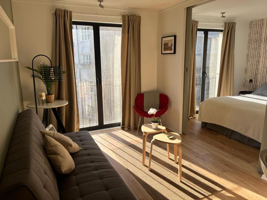 sala de estar con sofá, cama y ventanas en Departamento Barrio Lastarria, en Santiago