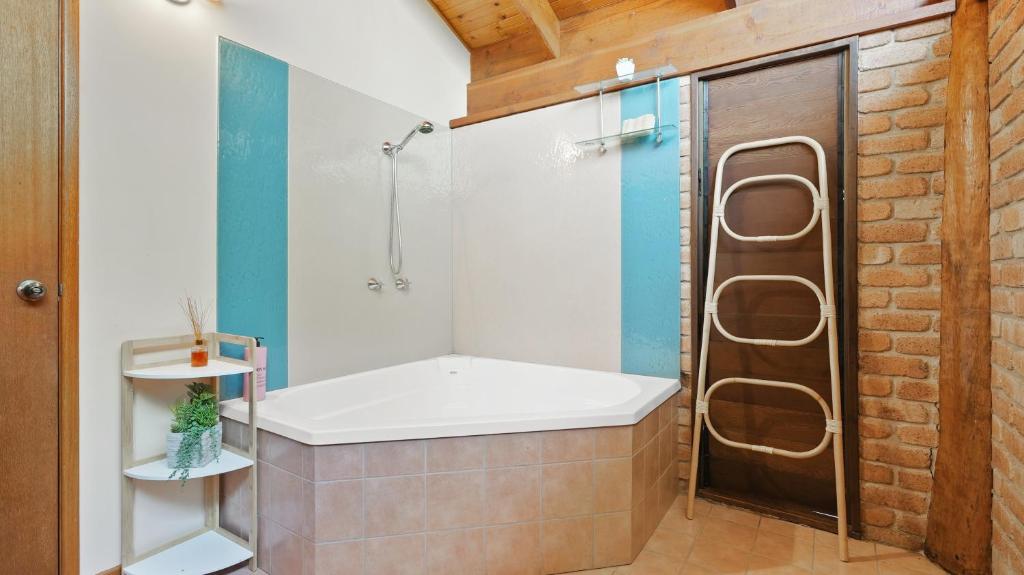 a bathroom with a bath tub and a shower at Rainforest Treehouse Sanctuary - with ocean views in Smithfield