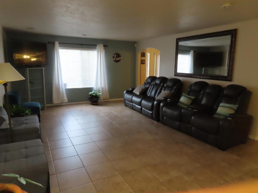 uma sala de estar com um sofá de couro preto e uma televisão em Beautiful, spacious home in ABQ em Albuquerque