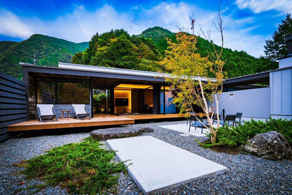 ein modernes Haus mit Bergen im Hintergrund in der Unterkunft UMEGASHIMA　DRIVEｰIN　＆　SAUNA　VILLA in Shizuoka