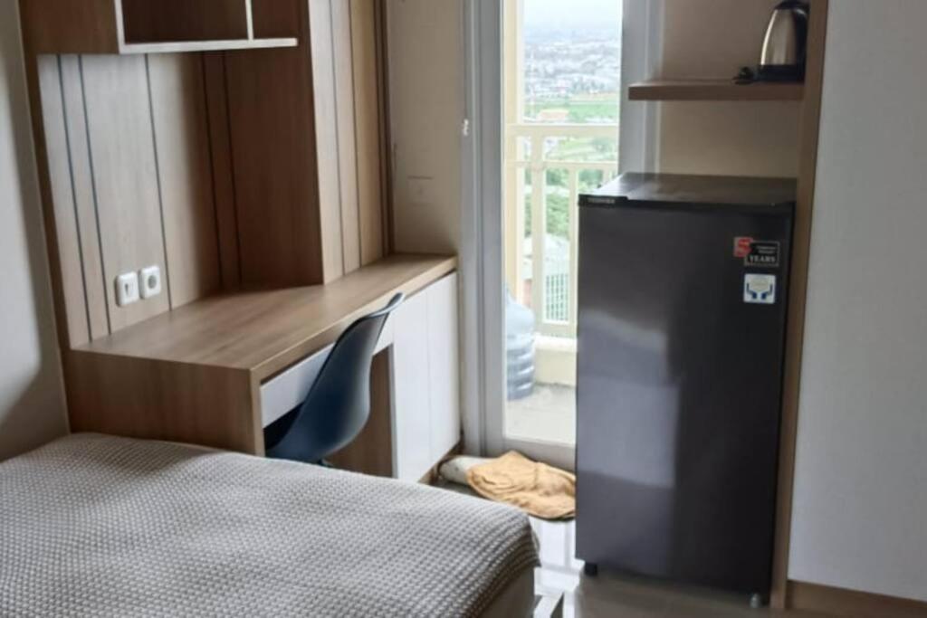 a small kitchen with a desk and a chair and a window at Student Haven Compact Studio at B Residence BSD in Tjilandak