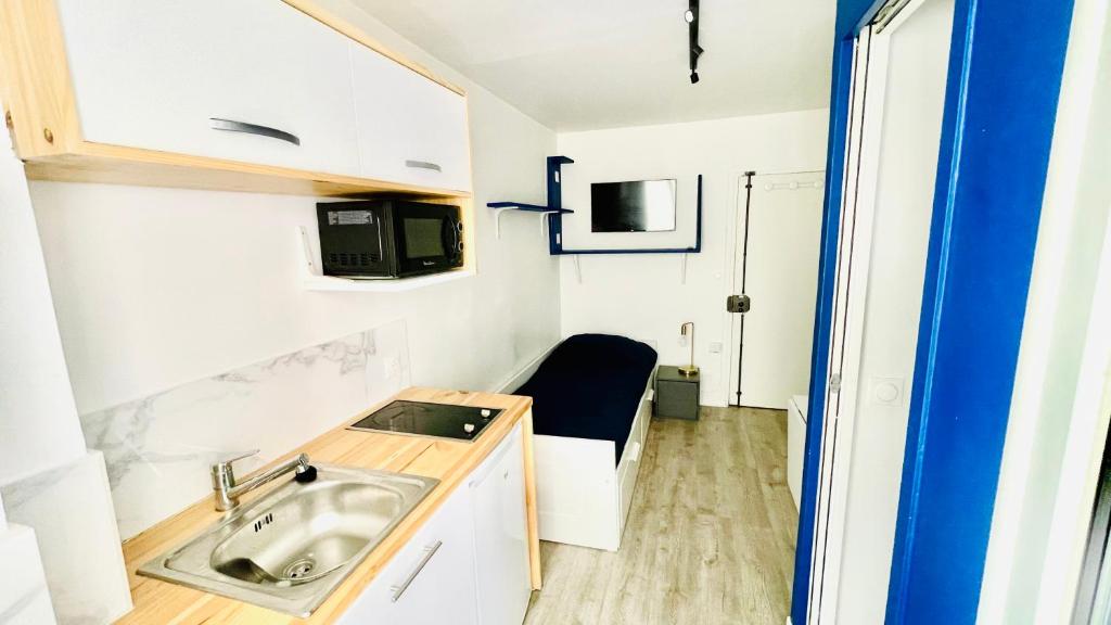 a small kitchen with a sink and a microwave at Joli Studio Parisien in Paris