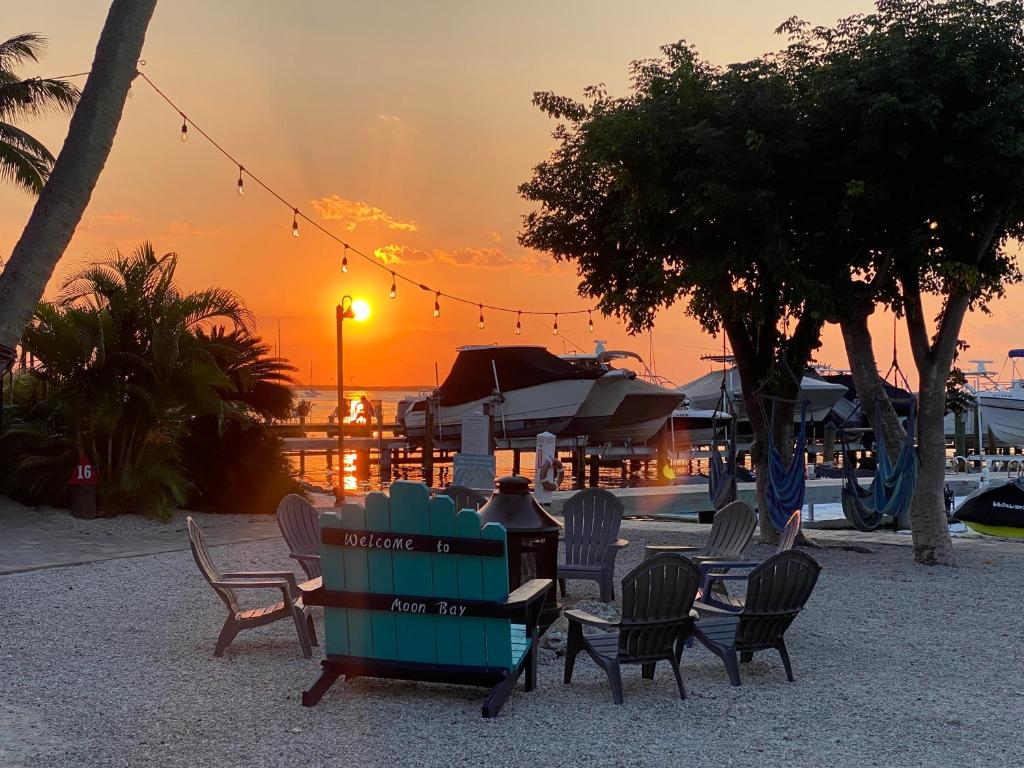 a person sitting at a table with chairs at sunset at Moon Bay Condo, Paradise Found in Sunny Key Largo, Florida in Key Largo