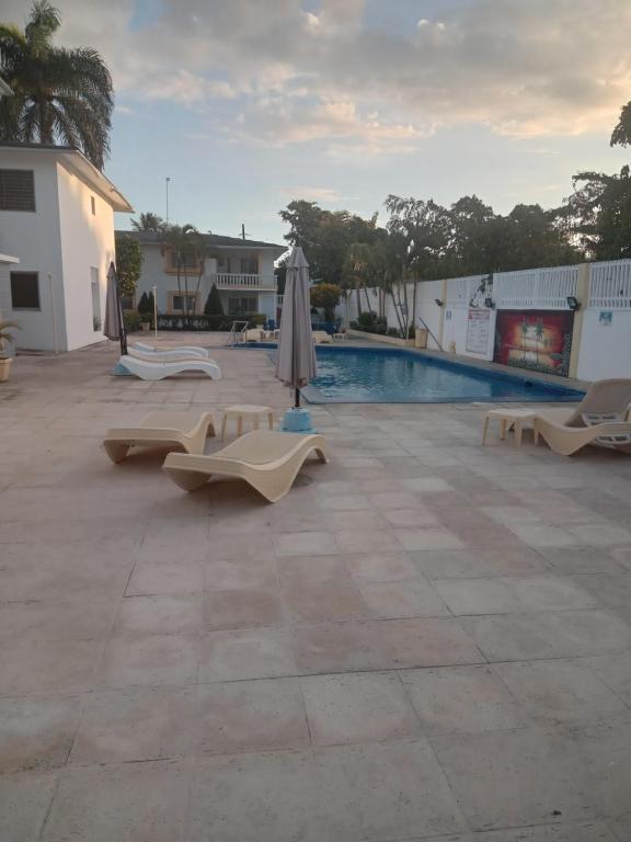 een zwembad met stoelen en parasols naast een zwembad bij Casitas del sol in Boca Chica