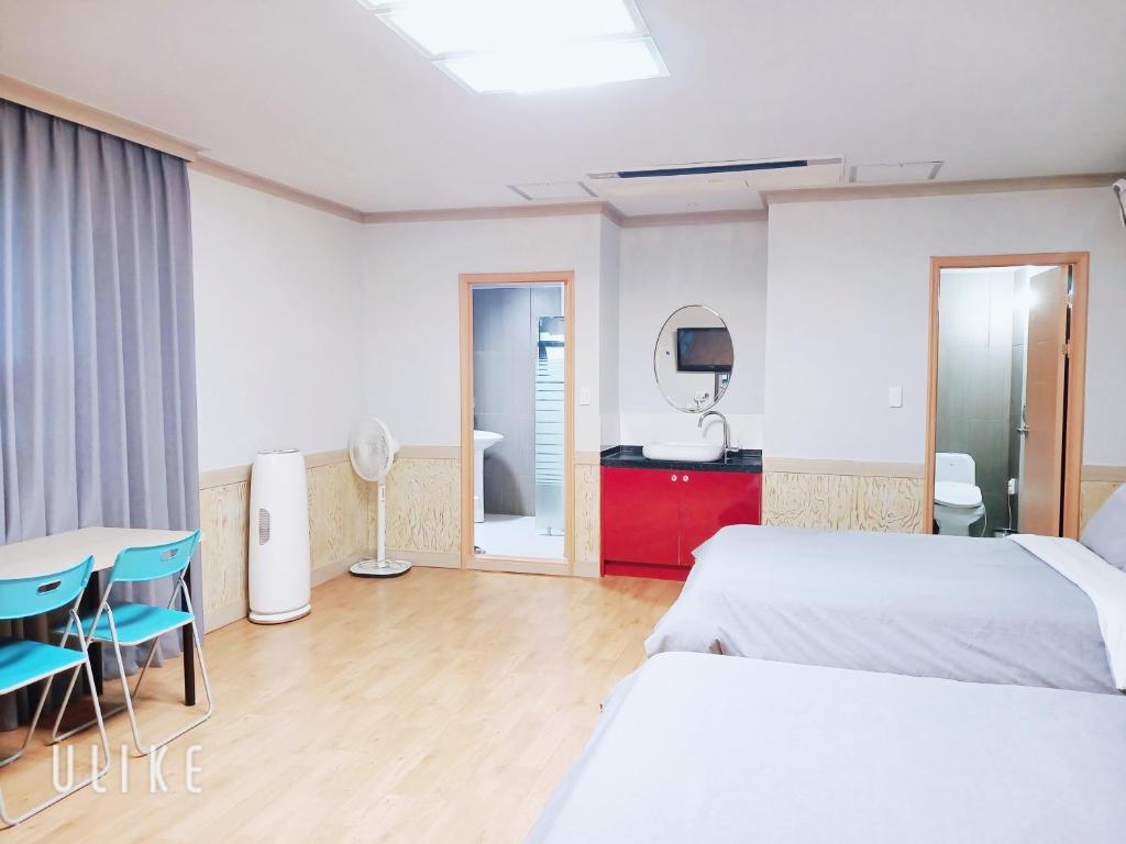 ein Hotelzimmer mit 2 Betten, einem Tisch und Stühlen in der Unterkunft Freshia Hotel in Incheon