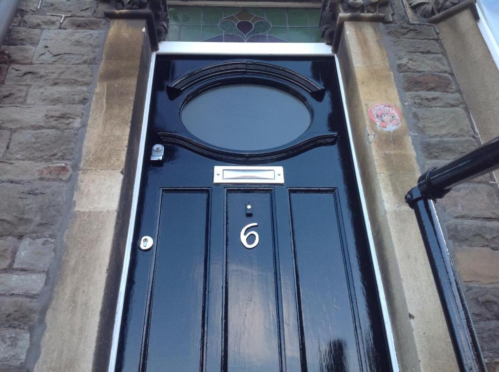 een blauwe deur met een rond raam erop bij Clift Guest House in Bristol