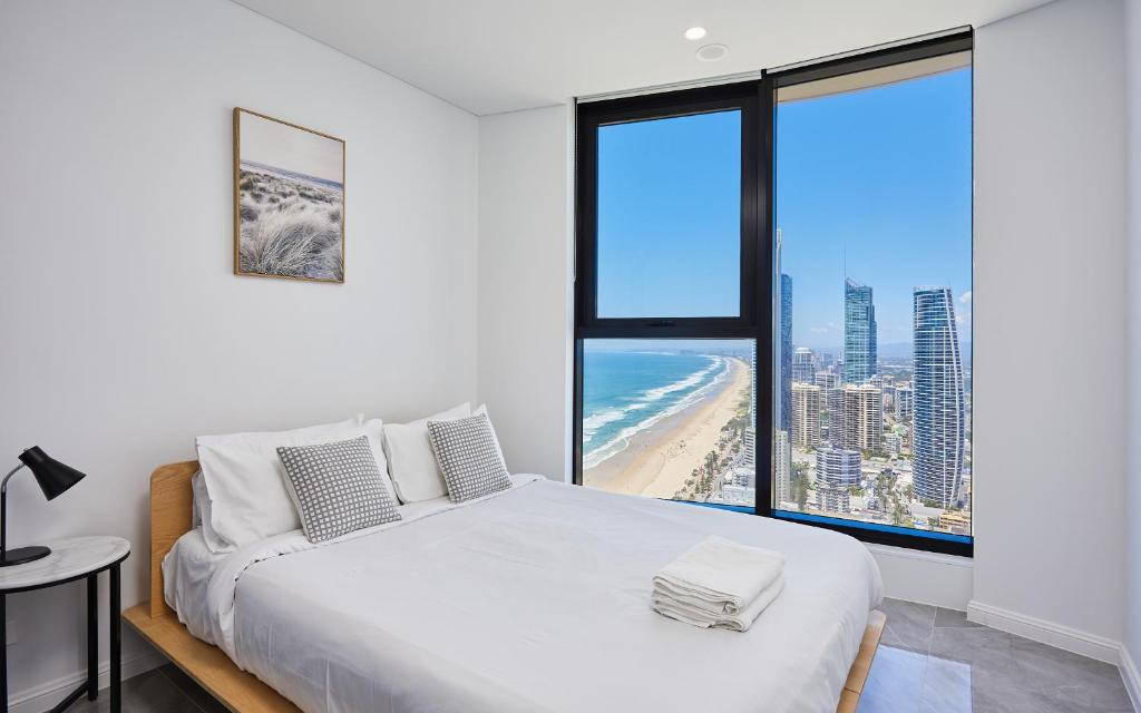 a bedroom with a bed and a view of the beach at Beachside Ocean view 1-bedroom apartment in Ocean Building in Gold Coast