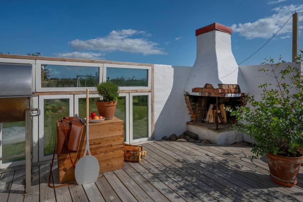 a patio with a fireplace and a building with windows at Farmhouse near Malmö in Trelleborg