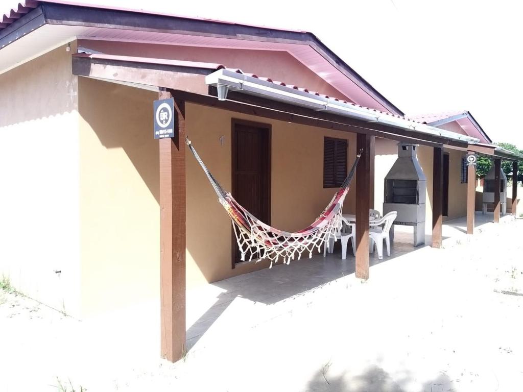 eine Hängematte, die an der Seite eines Gebäudes hängt in der Unterkunft Casas no Balneário Pérola / Arroio do Sal in Arroio do Sal