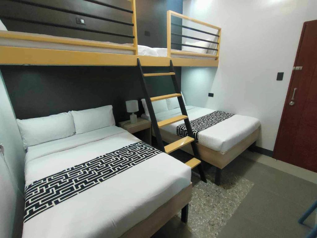Postel nebo postele na pokoji v ubytování SANDS Hotel Nasugbu