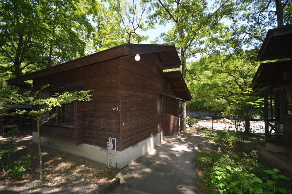 un pequeño edificio de madera en medio de árboles en Tabino Camping Base Akiu Tree House - Vacation STAY 23970v, en Yumoto