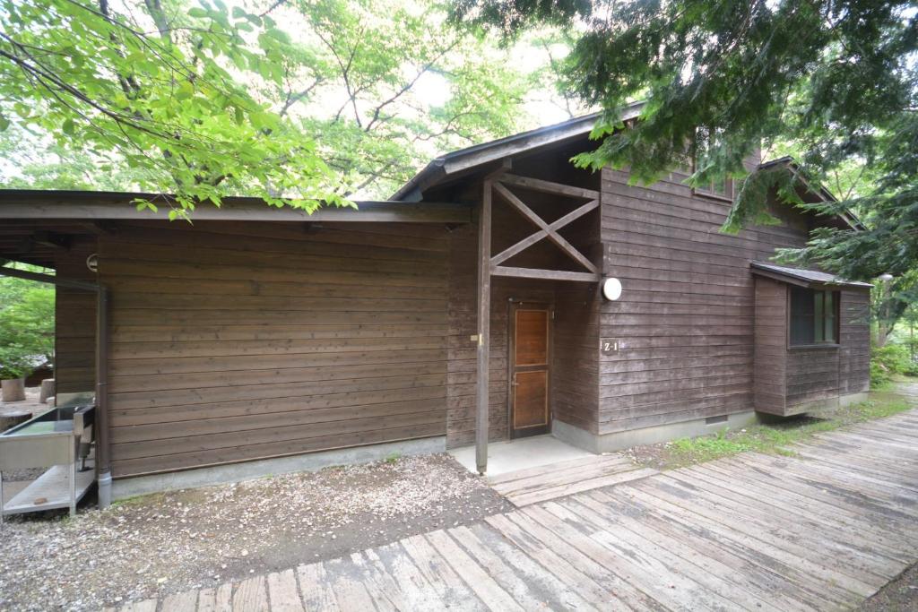 eine Holzhütte mit einer Holzterrasse davor in der Unterkunft Tabino Camping Base Akiu Tree House - Vacation STAY 23971v in Yumoto
