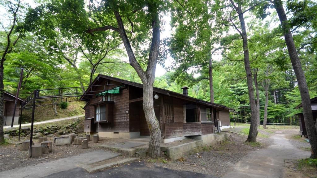 een kleine houten hut in het bos met bomen bij Tabino Camping Base Akiu Tree House - Vacation STAY 23973v in Yumoto