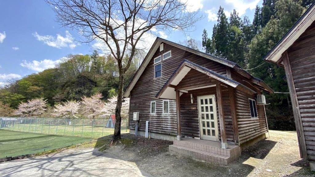 un pequeño edificio de madera con un árbol delante en Tabino Camping Base Kami Yuland - Vacation STAY 52575v en Osaki