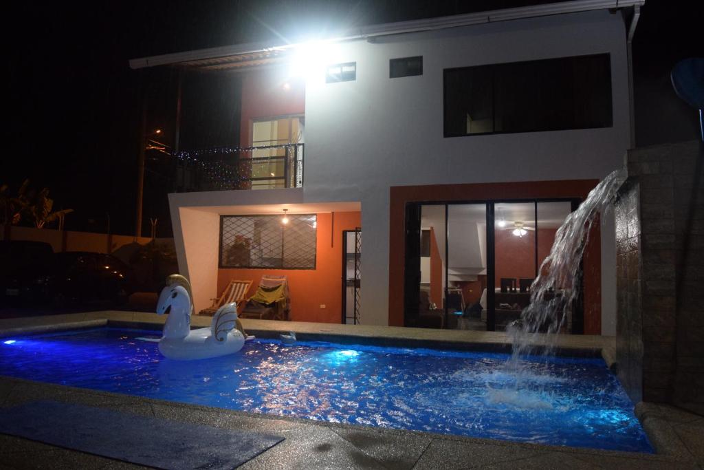 a swimming pool with a swan in front of a house at Casa privada en Tonsupa con piscina in Tonsupa