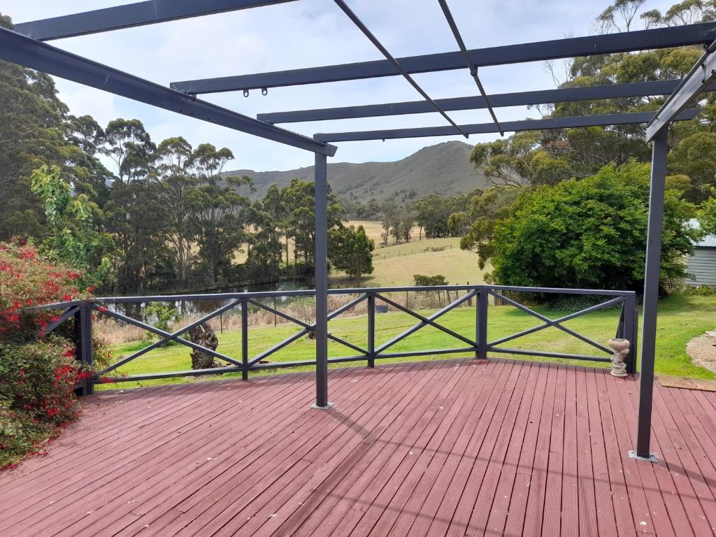 een overdekt terras met uitzicht op een veld bij Three Bedroom Escape with Room to Roam in Rocky Cape