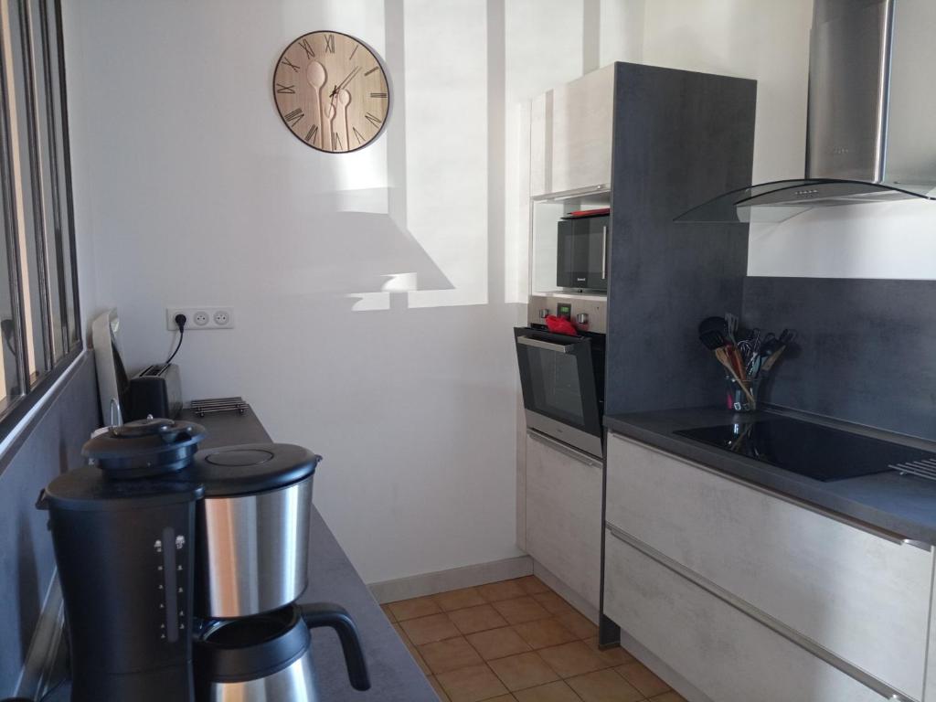 a kitchen with a sink and a clock on the wall at Gîte Arthon, 5 pièces, 8 personnes - FR-1-591-372 in Arthon