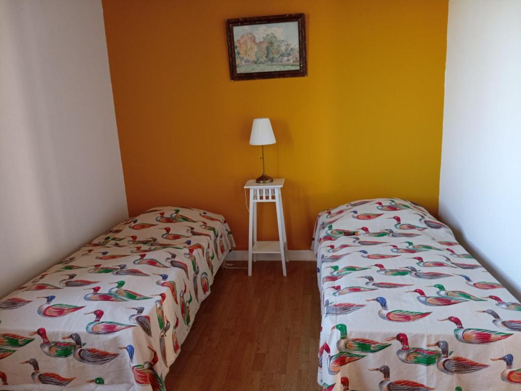 two beds in a room with yellow walls at Gîte Arthon, 5 pièces, 8 personnes - FR-1-591-372 in Arthon