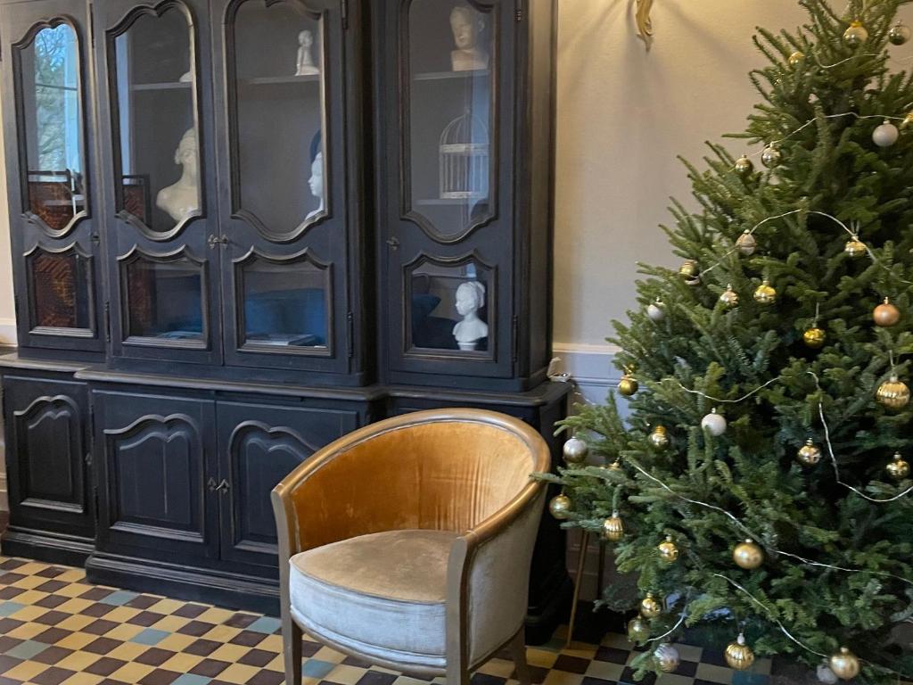 a chair and a christmas tree in a room at Gîte Bazouges-sur-le-Loir, 6 pièces, 10 personnes - FR-1-410-377 in Bazouges-sur-le-Loir