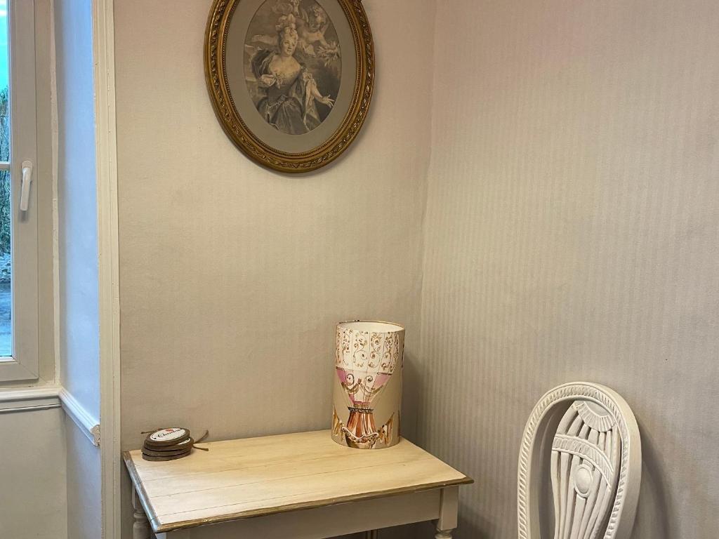 a table with a lamp and a clock on the wall at Gîte Bazouges-sur-le-Loir, 6 pièces, 10 personnes - FR-1-410-377 in Bazouges-sur-le-Loir
