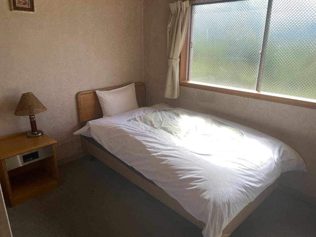 a bed in a bedroom with a window at Hotel Nissin Kaikan - Vacation STAY 02330v in Shiso