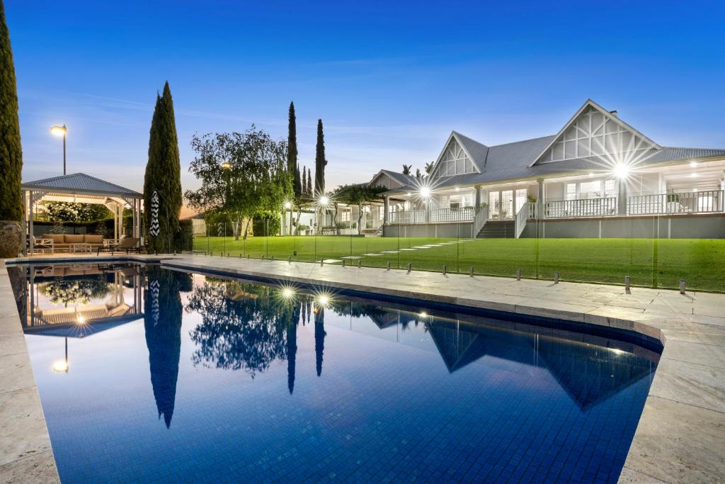 una casa con piscina frente a una casa en River Hamptons, en Berri