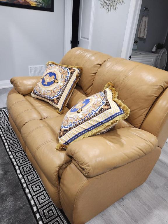 a brown leather couch with two pillows on it at SUITE A 2 Bedroom Apartment in Brampton