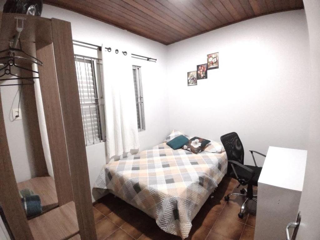 een slaapkamer met een bed en een bureau. bij ReGaGe in Florianópolis