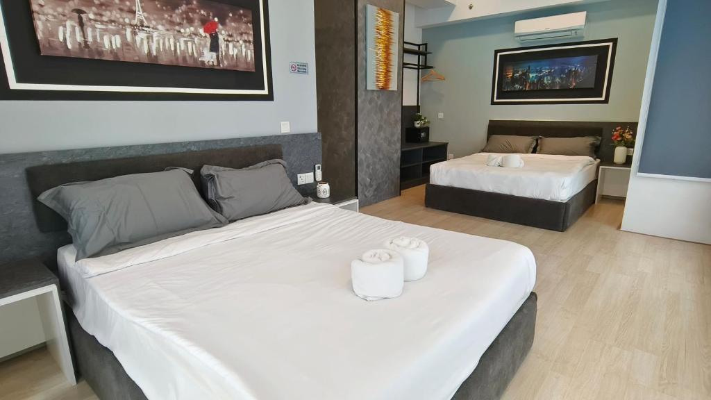 1 dormitorio con 2 camas y TV de pantalla plana en A3. The Sun @ Revo Aurora Pavillion, en Kuala Lumpur