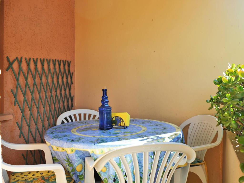 une bouteille bleue assise sur une table avec des chaises dans l'établissement T2 cabine avec loggia, proche plage et commerces, parking inclus - Bormes-les-Mimosas - FR-1-251-521, à Bormes-les-Mimosas