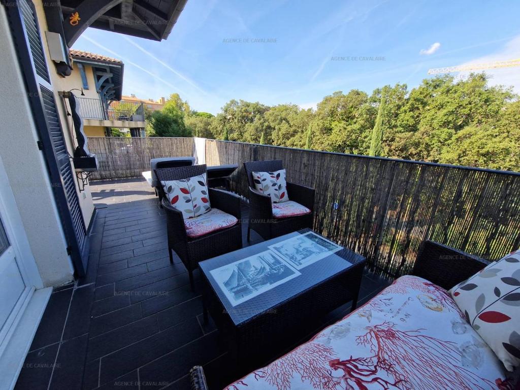 un patio avec deux chaises et une table sur un balcon dans l'établissement Appartement T3 avec piscine et terrasse, à 200m du centre de La Croix-Valmer - FR-1-100-324, à La Croix-Valmer
