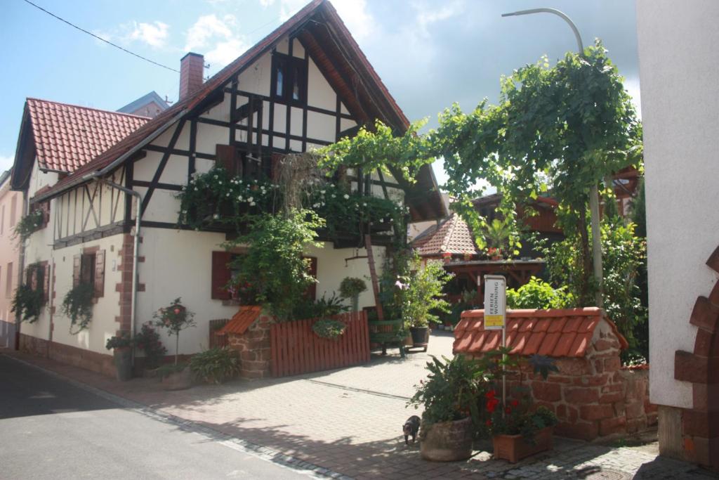 a white and black building with plants on it at Ferienwohnung Familie Westermann in Kapellen-Drusweiler