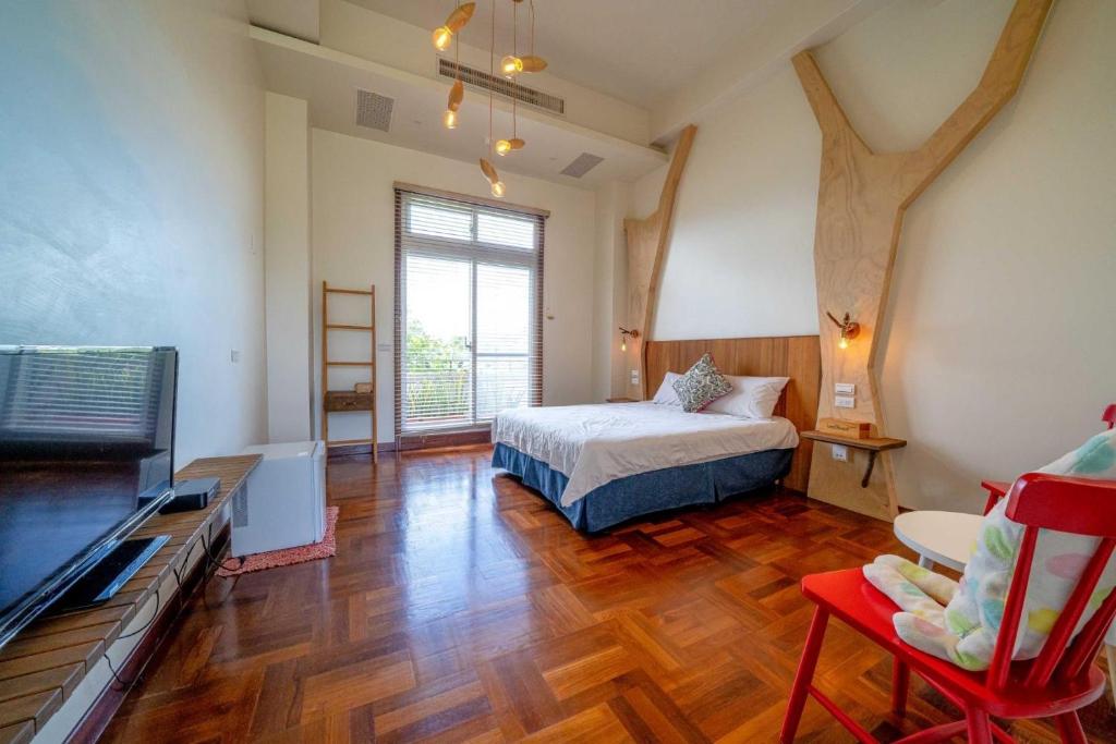 a bedroom with a bed and a tv in it at Yun Tien Feng Chuan B&amp;B in Dongshan