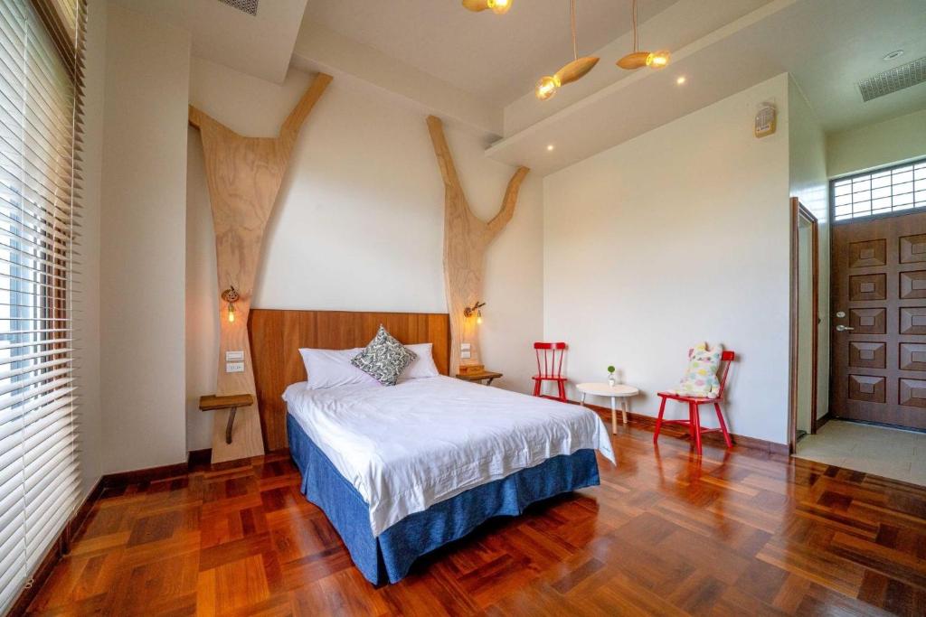 a bedroom with a bed and a table and chairs at Yun Tien Feng Chuan B&amp;B in Dongshan