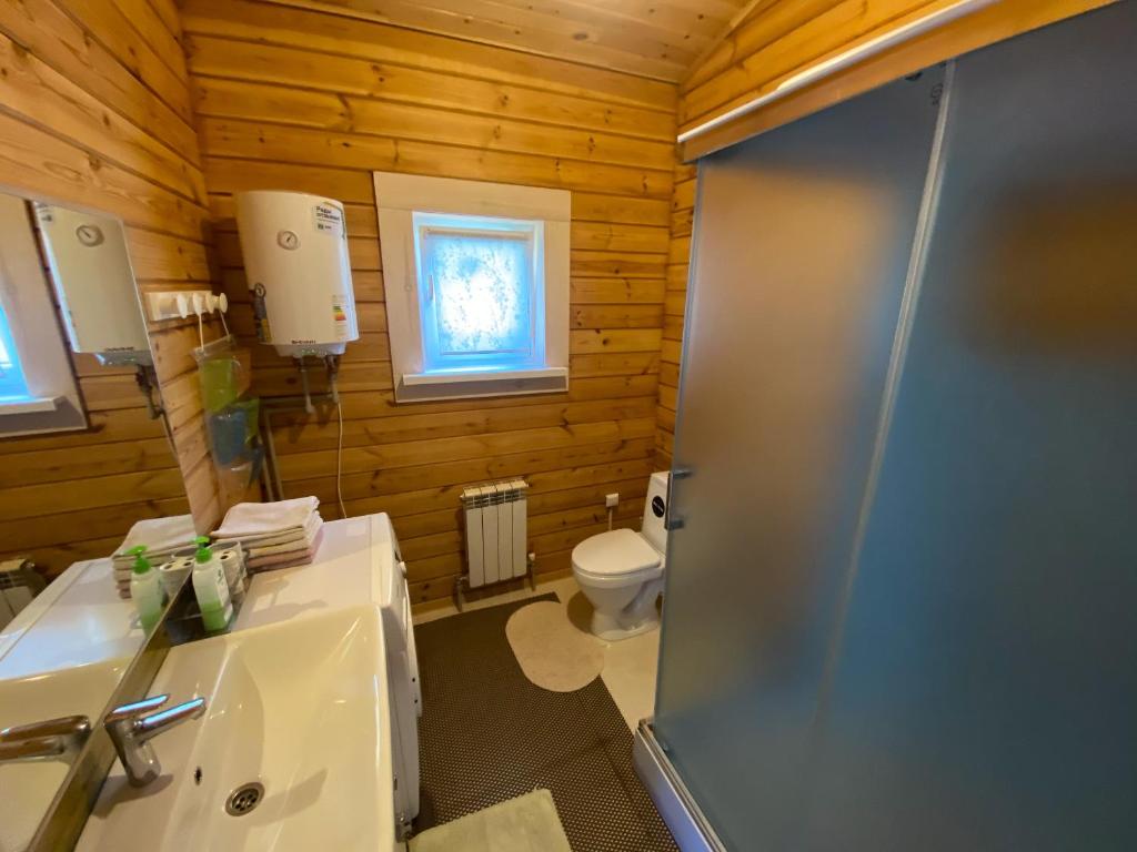 een badkamer met een toilet, een wastafel en een douche bij Милая квартира премиум класса in Alma-Ata