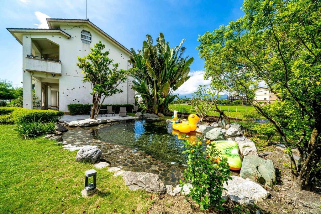 a backyard pond with two rubber ducks in a yard at Yun Tien Feng Chuan B&amp;B in Dongshan