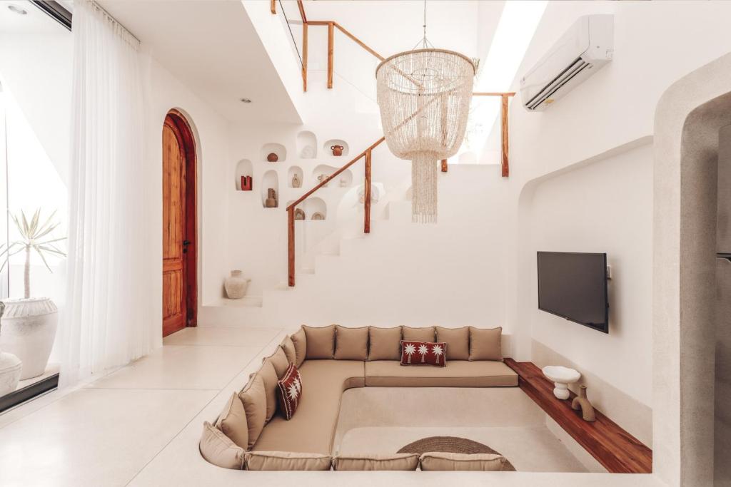 Una sala de estar con un sofá y un televisor. en Casa Cherish 2 BR Canggu Villa, en Canggu