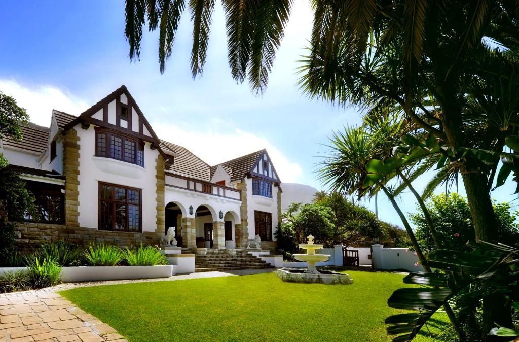 a house with a green lawn in front of it at St James Guest Houses in Kalk Bay