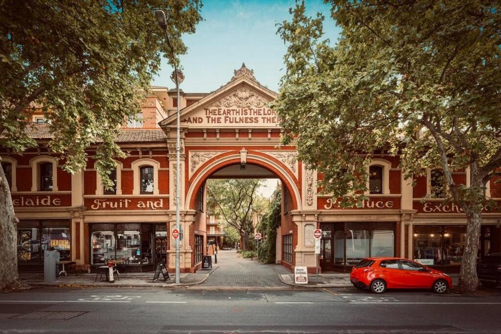 um carro vermelho estacionado em frente a um edifício com um arco em Charlie on Charlick - Fully Renovated 1BR Apt em Adelaide