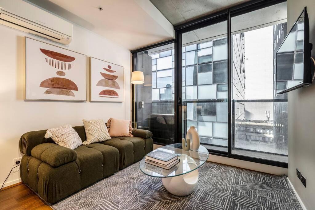 uma sala de estar com um sofá e uma mesa de vidro em Central Charm Small Studio Retreat in Melbourne em Melbourne