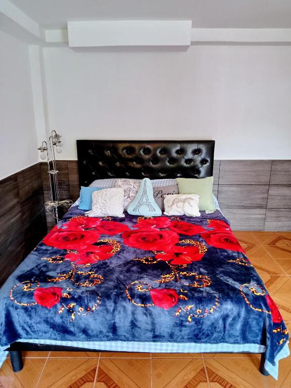 Un dormitorio con una cama con flores rojas. en Studio Luna, en Pereira