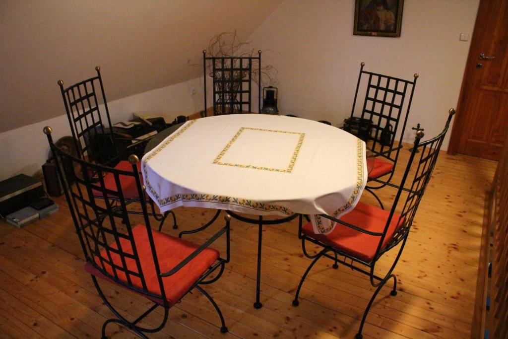 een eettafel met 4 stoelen en een witte tafel bij Holiday Home U Ryšavých in Busin