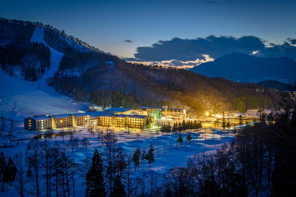 een hotel in de bergen 's nachts in de sneeuw bij Hotel Tangram in Shinano