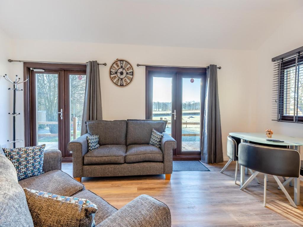 a living room with a couch and a table at Kestrel Lodge in Little Witley