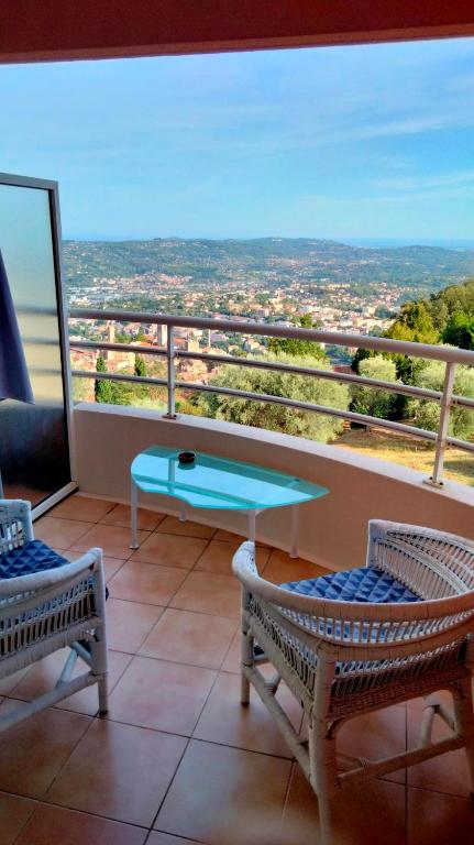 un balcon avec une table et des chaises et une vue dans l'établissement Beau Studio au calme avec coin nuit, à Grasse