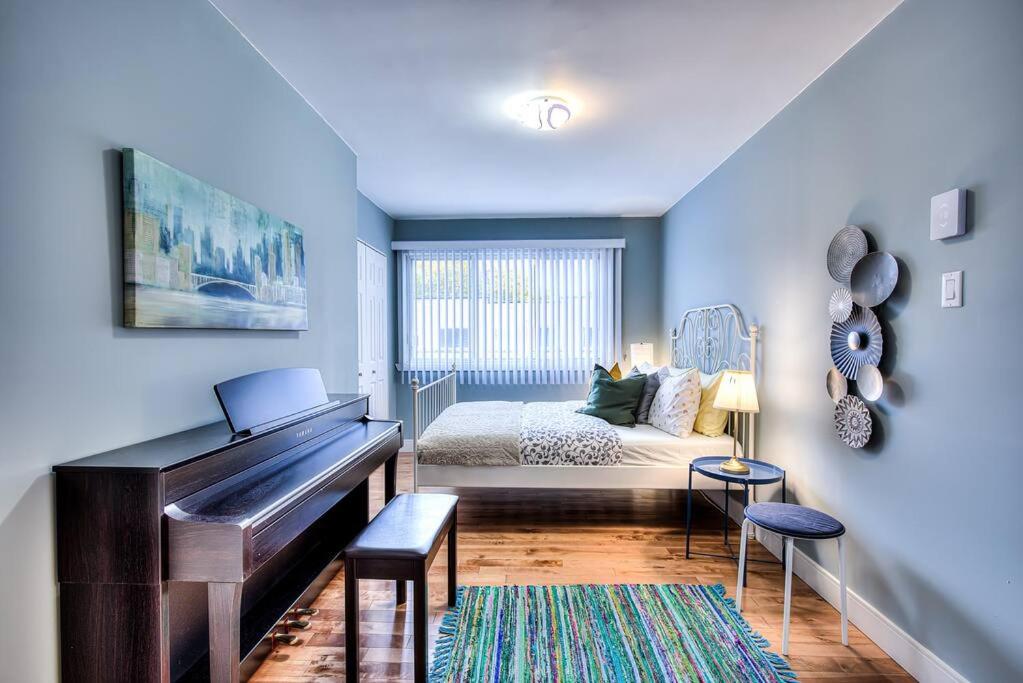 Un dormitorio con un piano y una cama. en Charming 2BR with Balcony in Montreal, en Montreal