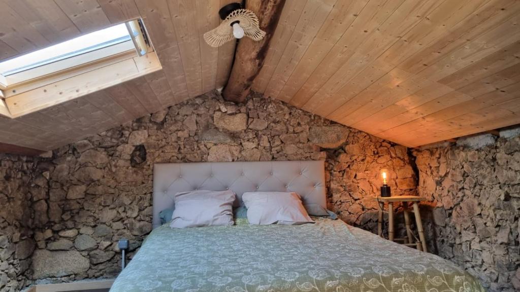 a bedroom with a bed in a stone wall at Langhjuledda in Grosseto-Prugna