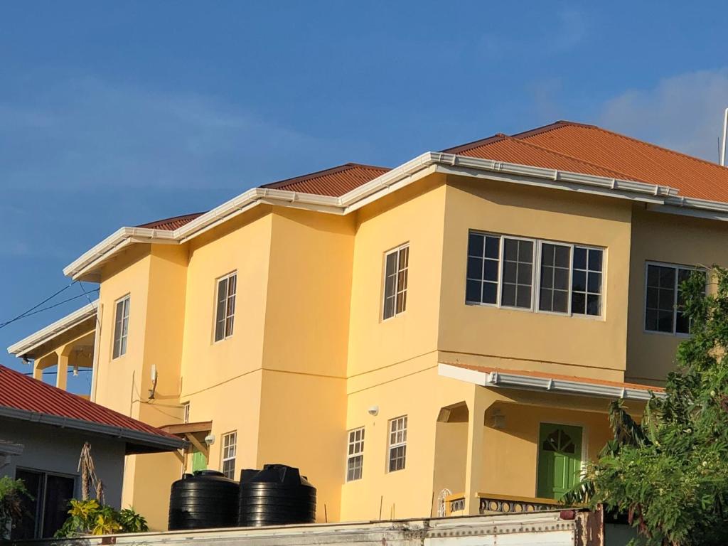 a yellow house with a red roof at Patrickville in Gwa Kay