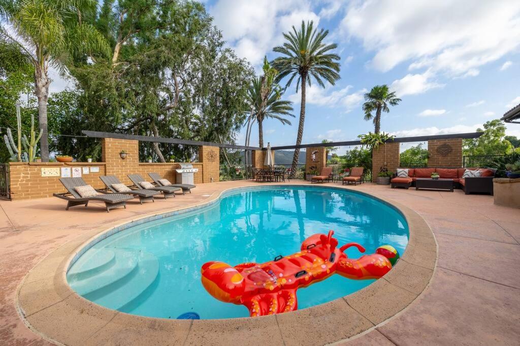 una gran piscina con un perro inflable en el medio en Tropical, Private, Heated pool, Petting zoo!, en Vista